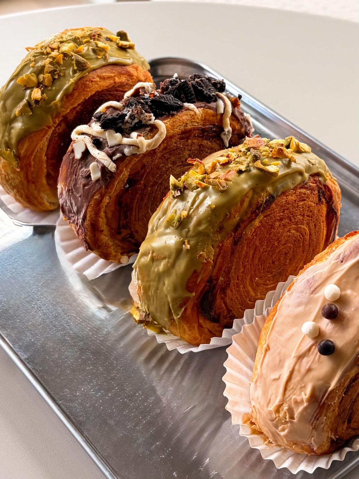 Gevulde croissants met pistache, Oreo en witte chocolade op een bakplaat